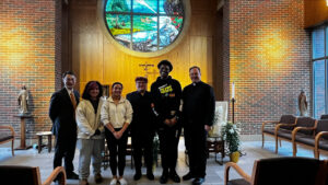 Green Bay West High School alums who attend Marquette University pose with Fr. Theide.